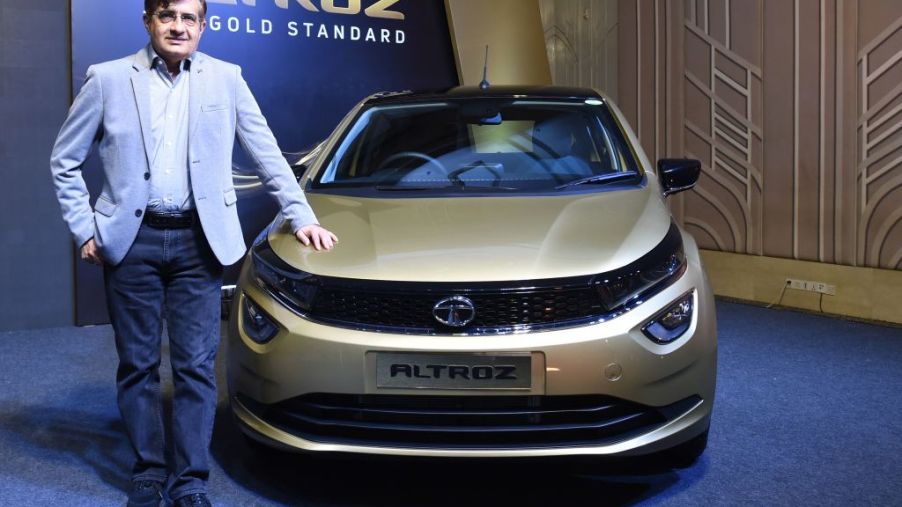 The President of Tata Motors stands next to one of the company's cars