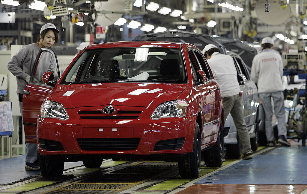 Workers inspect Toyota Corolla at a factory
