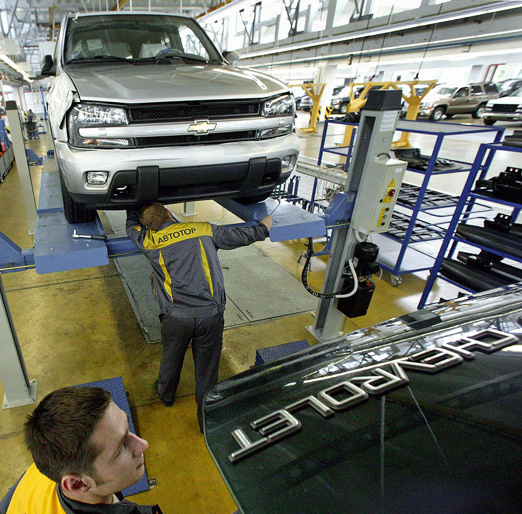A man assembles a Chevy Trailblazer in a factory