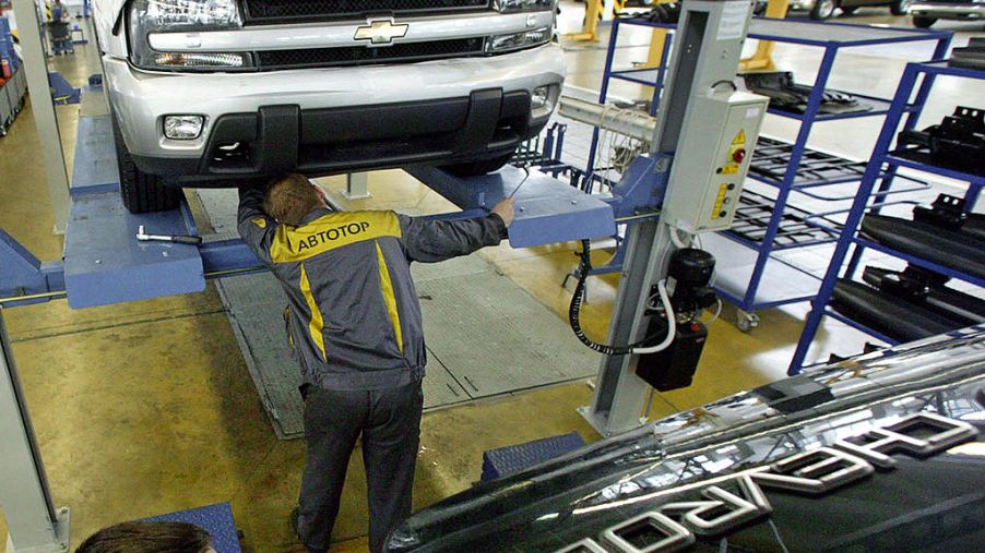 A man assembles a Chevy Trailblazer in a factory