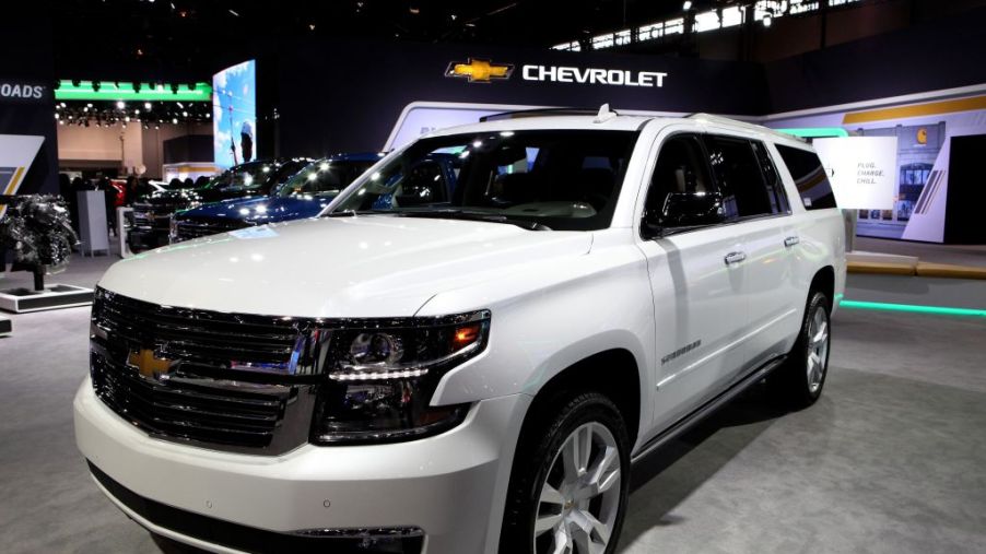 A white Chevy Suburban on display at an auto show