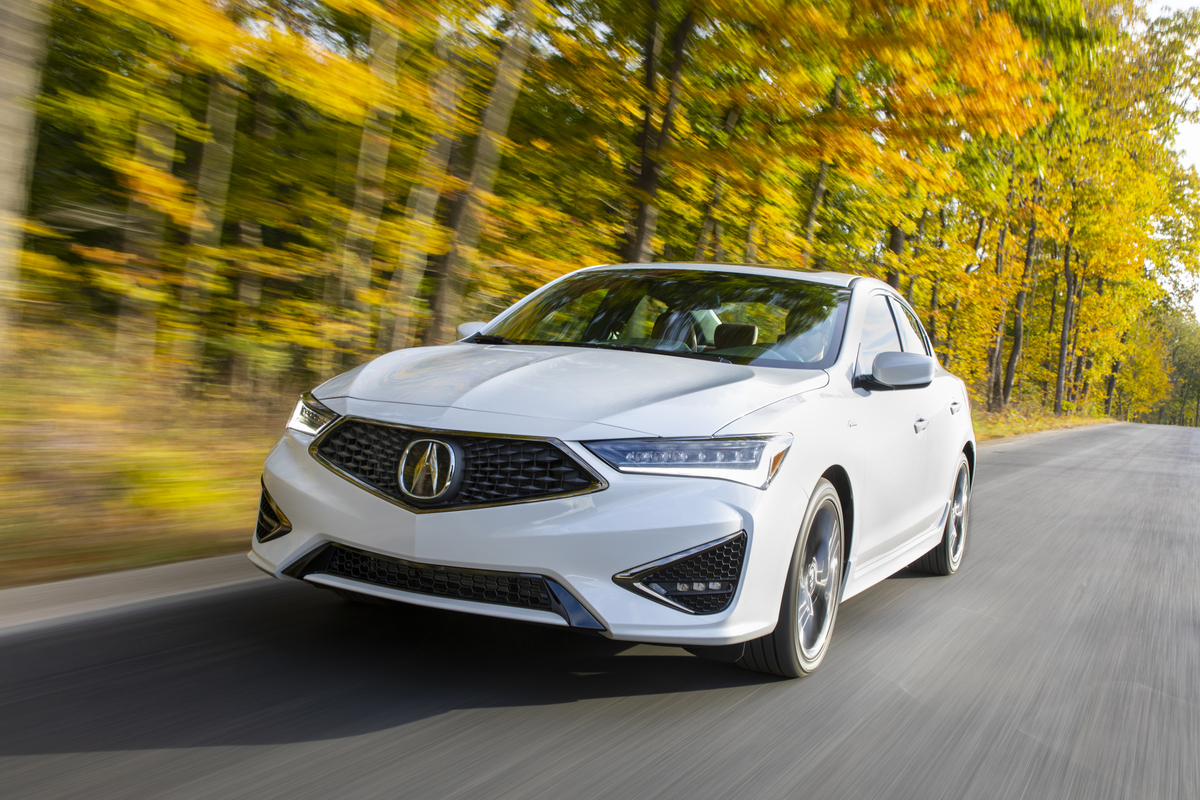 White 2020 Acura ILX A-Spec driving down a fall forest road
