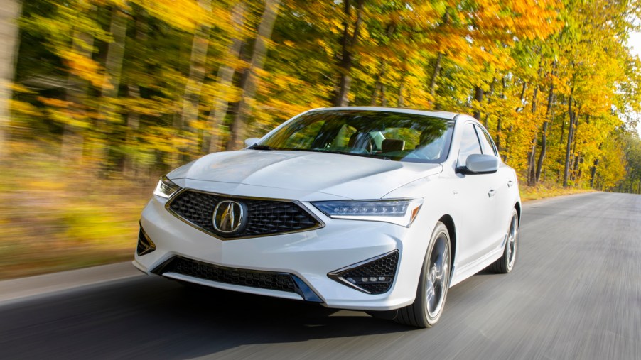 White 2020 Acura ILX A-Spec driving down a fall forest road