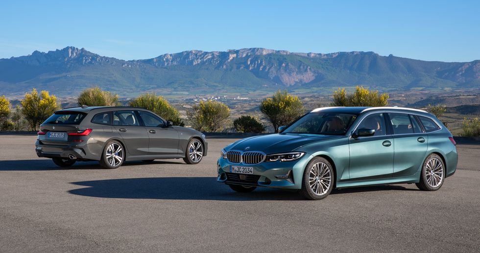 the BMW 3 series sedan and wagon parked on pavement with a scenic mountainous background