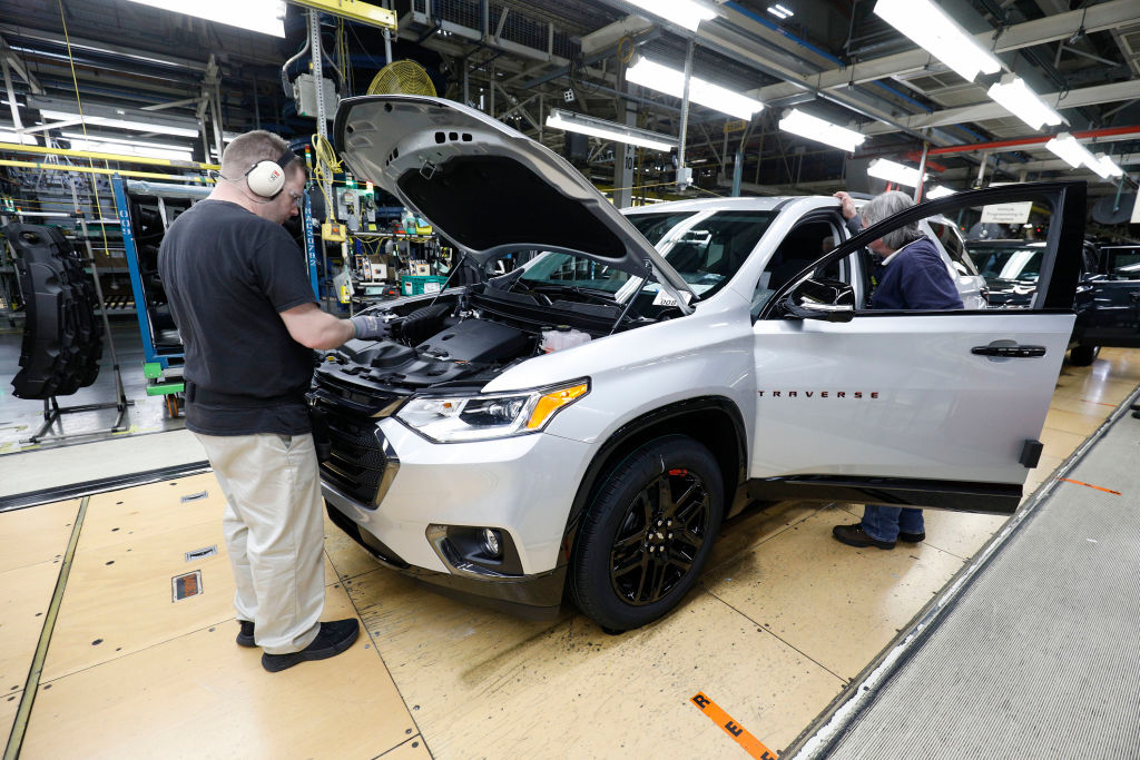 A Buick Enclave being assembled by a worker