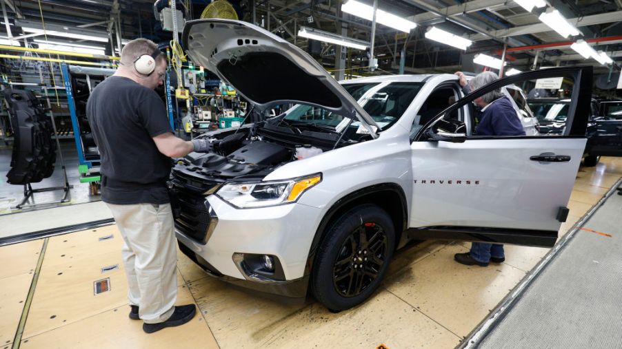 A Buick Enclave being assembled by a worker
