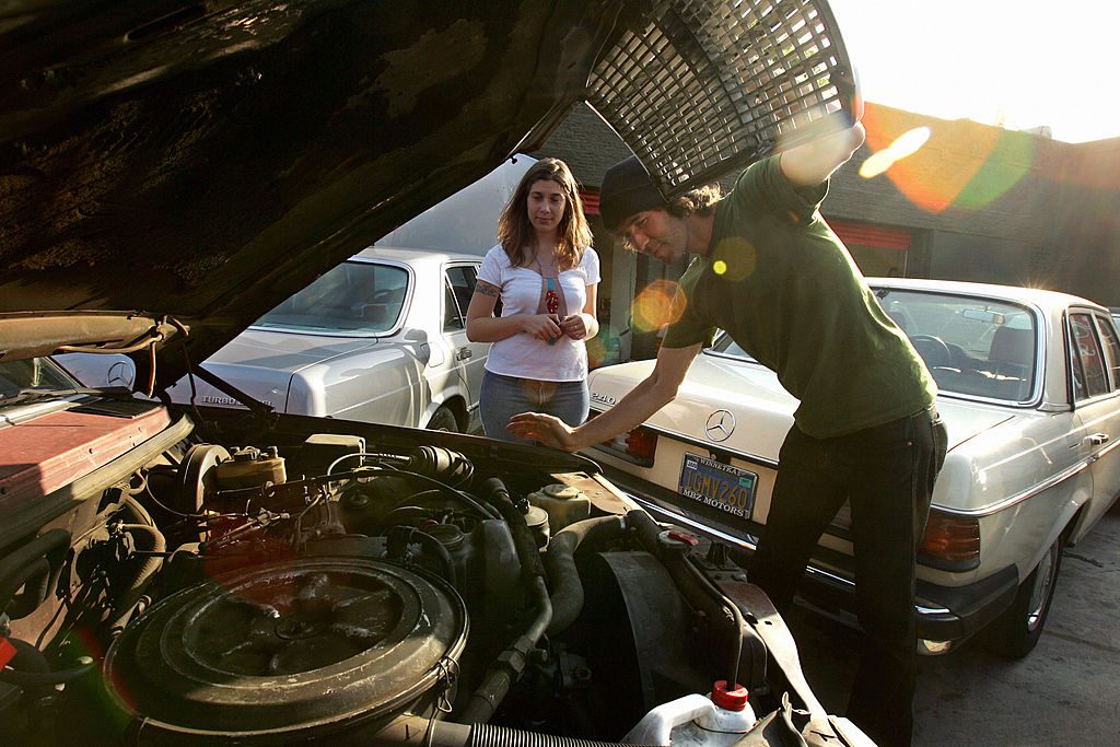 A man looking over his car, getting ready to change his oil