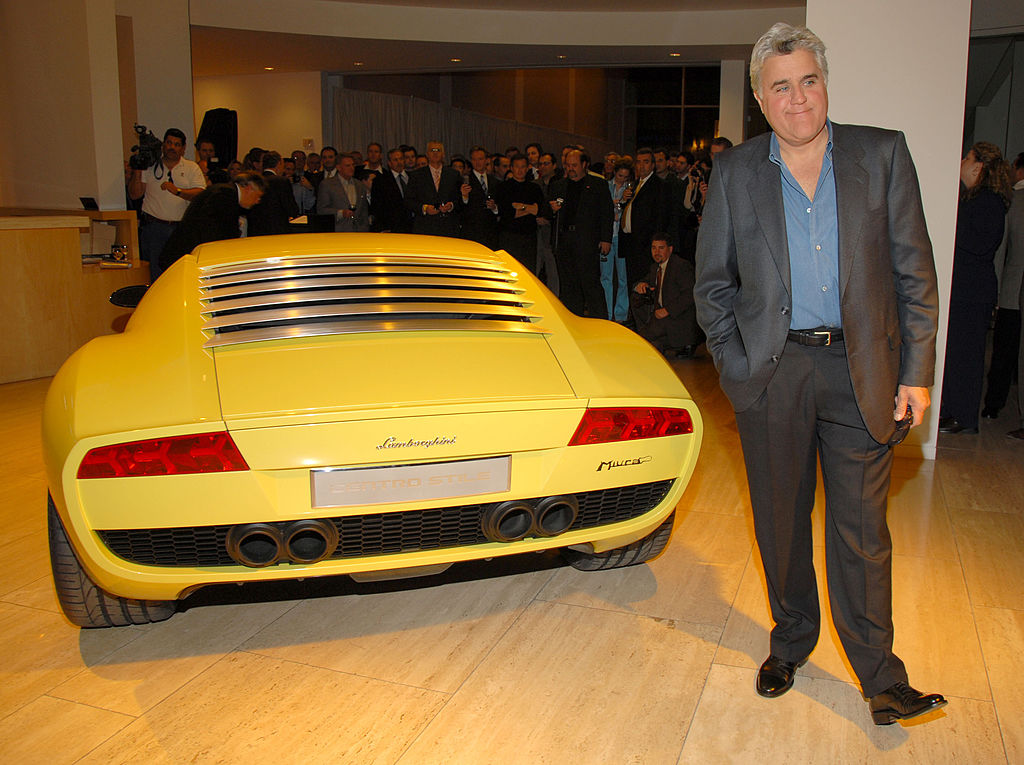 Jay Leno posing next to a Lamborghini Miura concept car