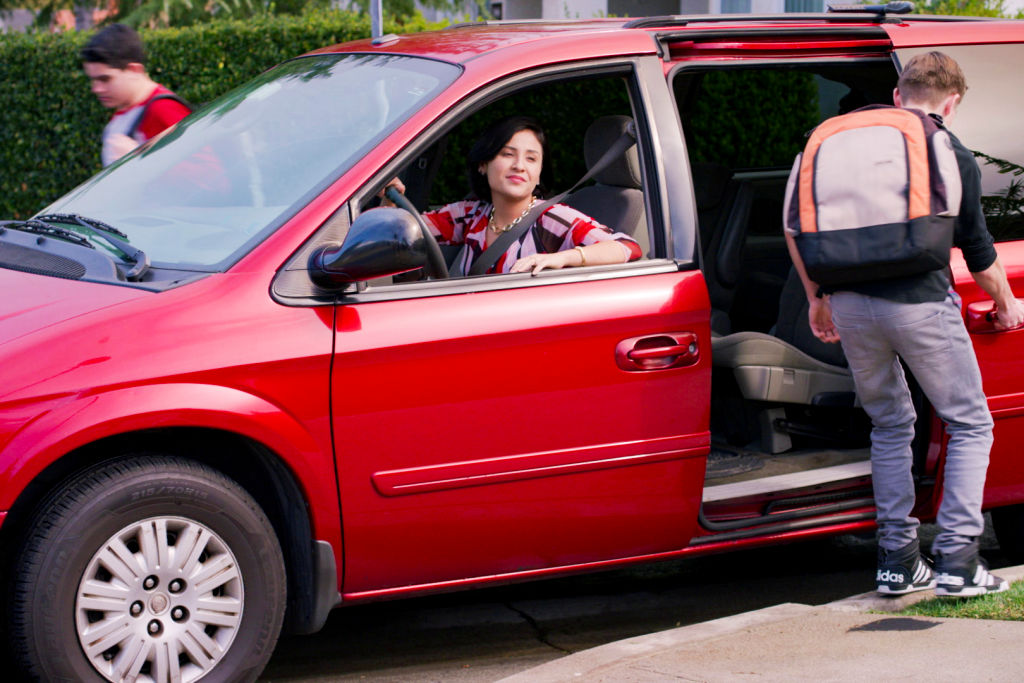 A mom picking up her kids in a minivan