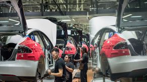 A worker assembles Tesla cars in a factory