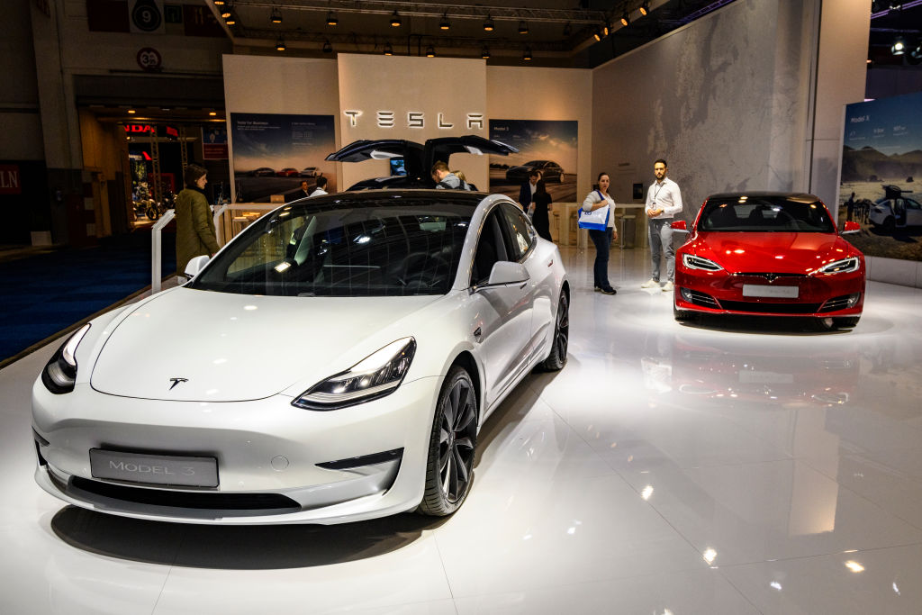 Tesla Model 3 compact sedan car in white with a Tesla Model S dual motor all electric sedan on display at Brussels Expo