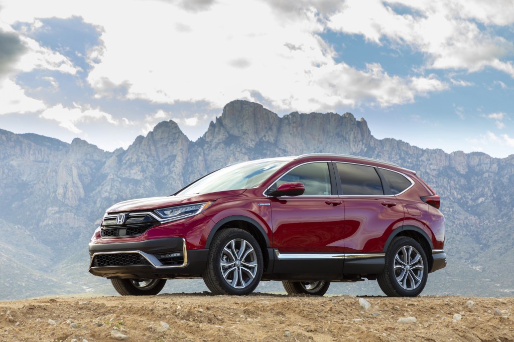 a red 2020 Honda CR-V Hybrid crossover in a mountainous landscape