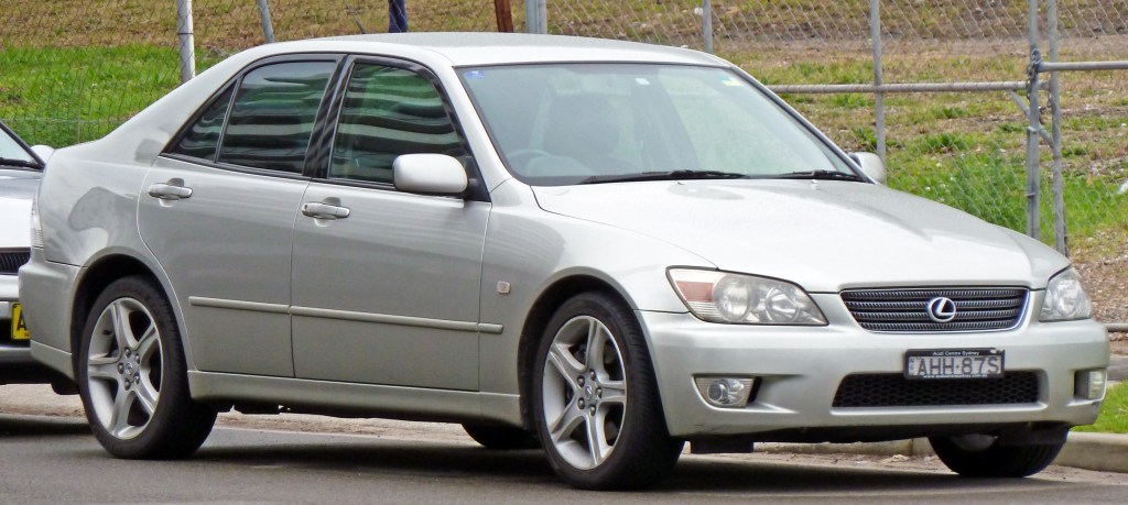 A silver 2001 Lexus IS 300 parked by the side of a country road.