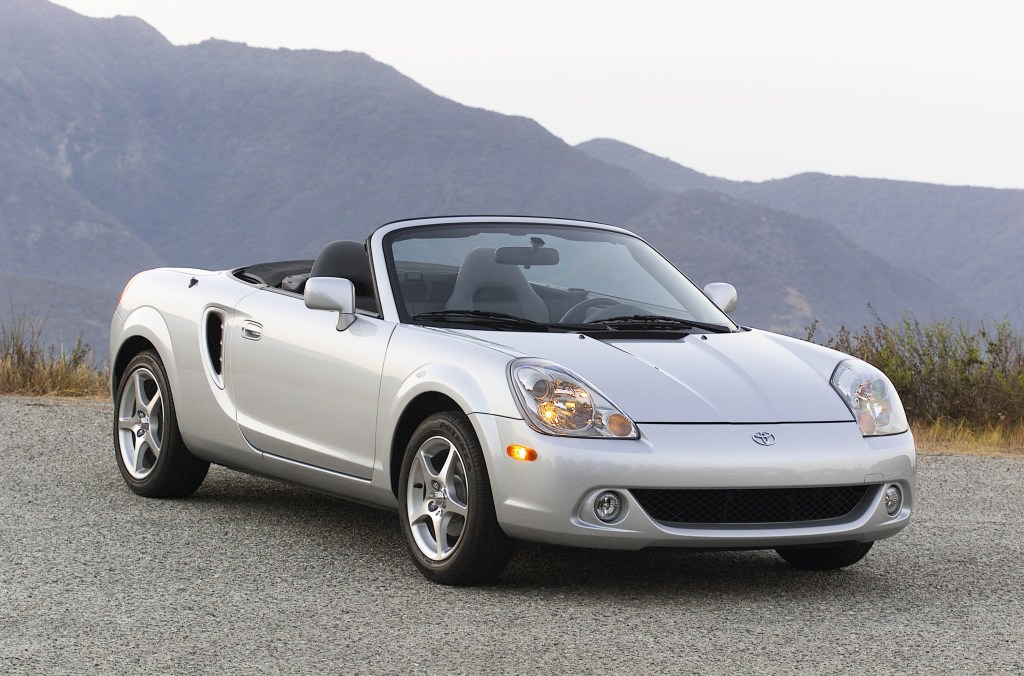 A silver 2003 Toyota MR2 Spyder parked at a scenic outlook.