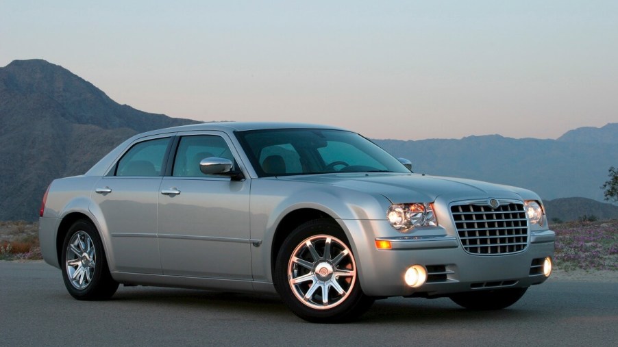 A silver 2006 Chrysler 300 shows off its lines with its lights on.