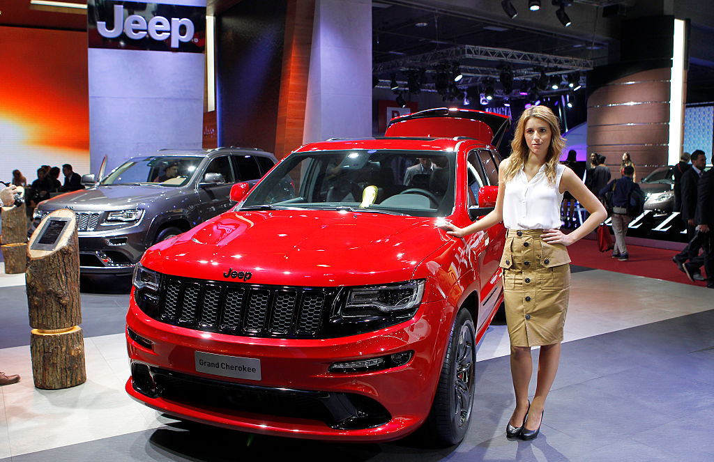 A model poses next to a Jeep Grand Cherokee during the second press day of the Paris Motor Show