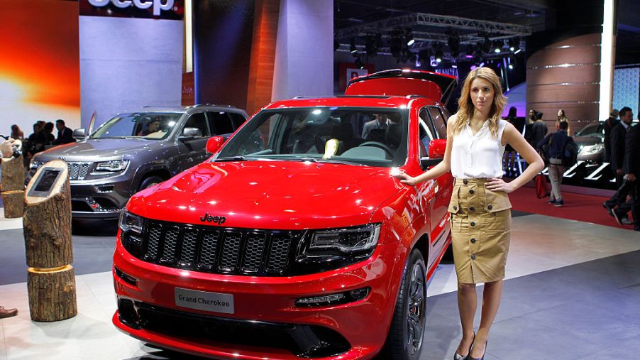 A model poses next to a Jeep Grand Cherokee during the second press day of the Paris Motor Show