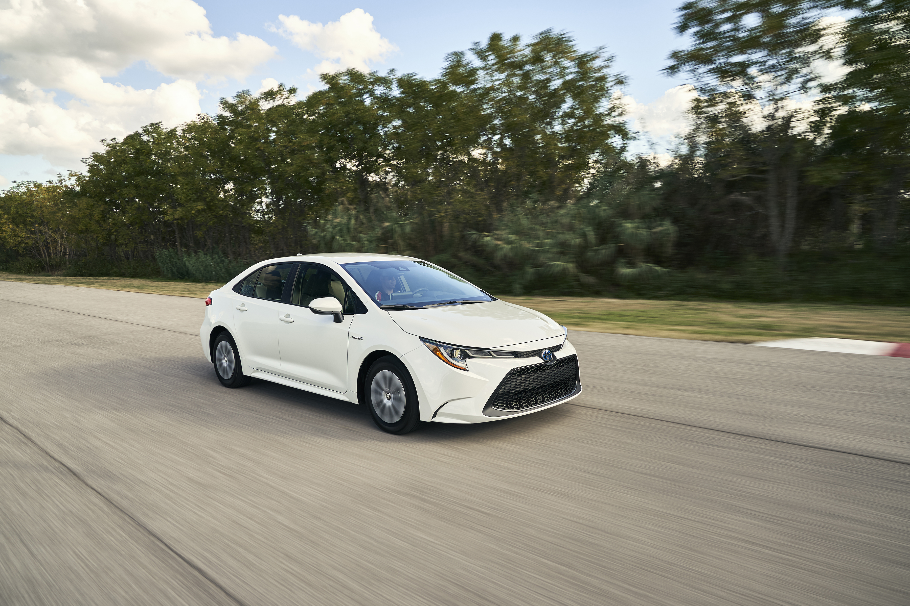 a white 2020 Toyota Corolla at speed on a scenic road
