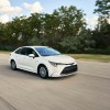a white 2020 Toyota Corolla at speed on a scenic road