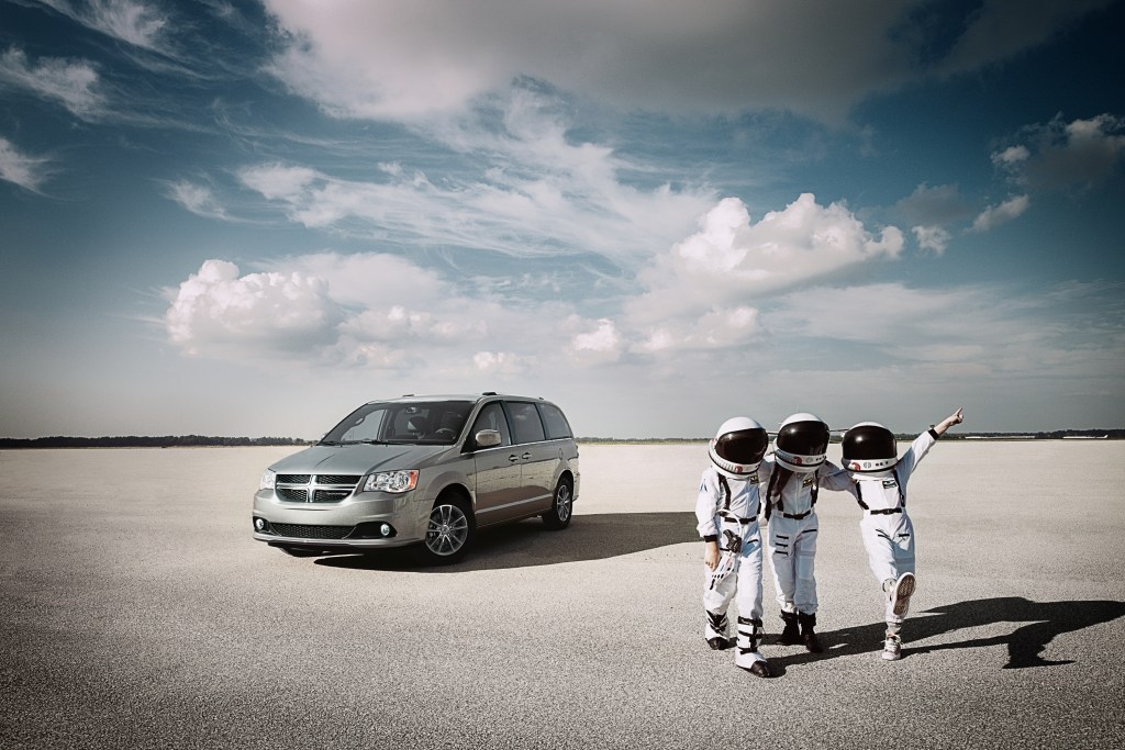 Astronauts standing near the Grand Dodge Caravan
