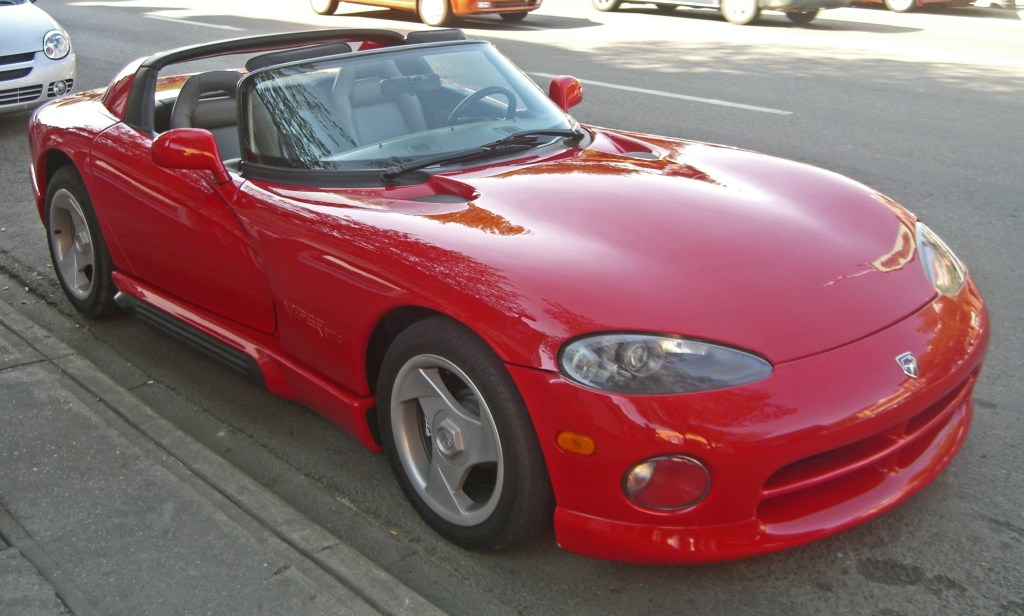 A red 1993 Dodge Viper RT/10 is parked by the side of an urban street.