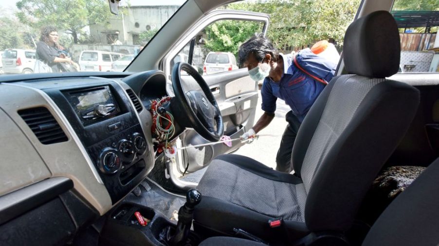 DTC cleaning staff chemically disinfect and sanitize a taxi as a precautionary measure in view of coronavirus concerns