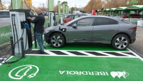 A man charges an electric car at an electric car charging station set up ahead of the UNFCCC COP25 climate conference
