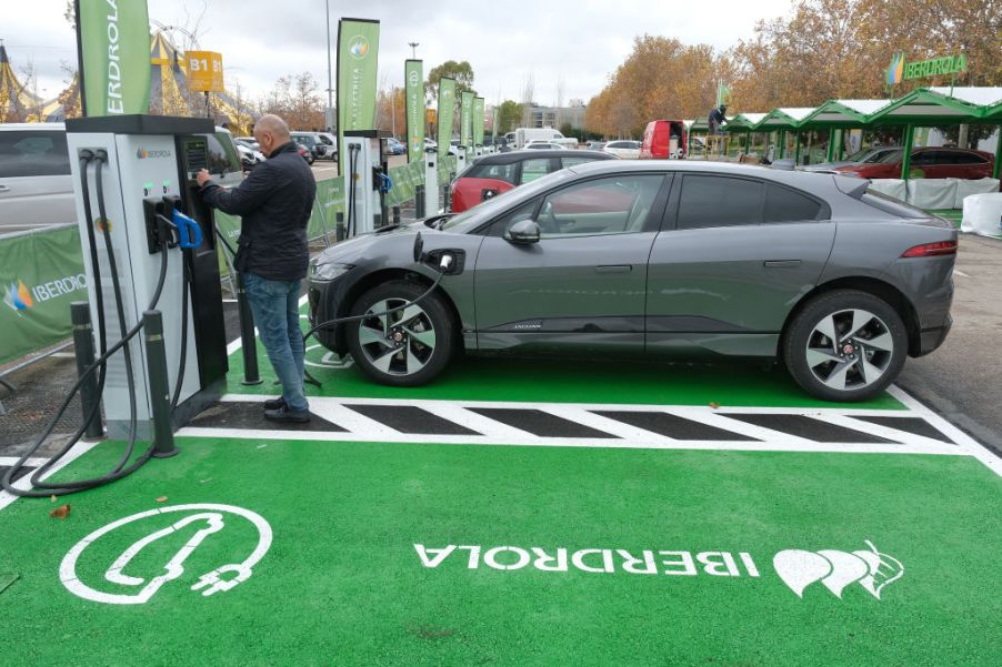 A man charges an electric car at an electric car charging station set up ahead of the UNFCCC COP25 climate conference