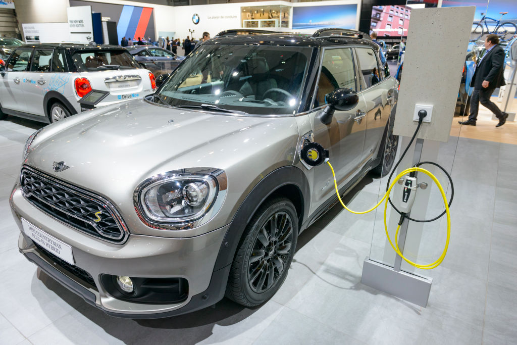 A silver Mini Cooper SE Electric plugged into a charger.