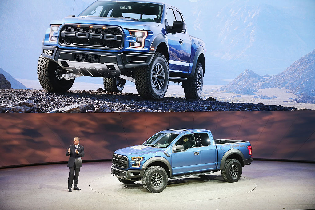 Ford Raptor being presented by a business man at an auto show 