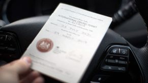 An International Driving Permit placed on top of a steering wheel.
