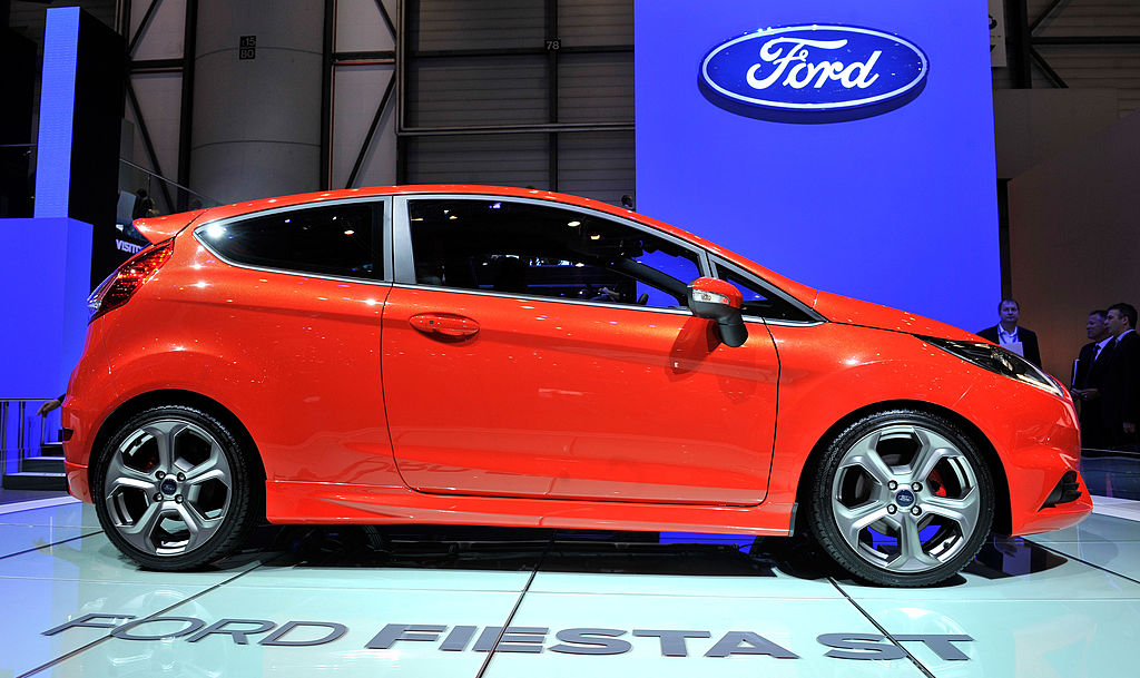 An orange Ford Fiesta ST showcased at an automotive show.