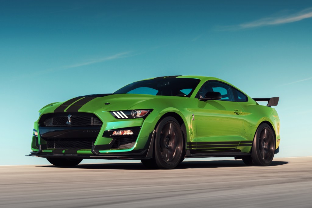 A lime green 2020 Ford Mustang driving down a race track.
