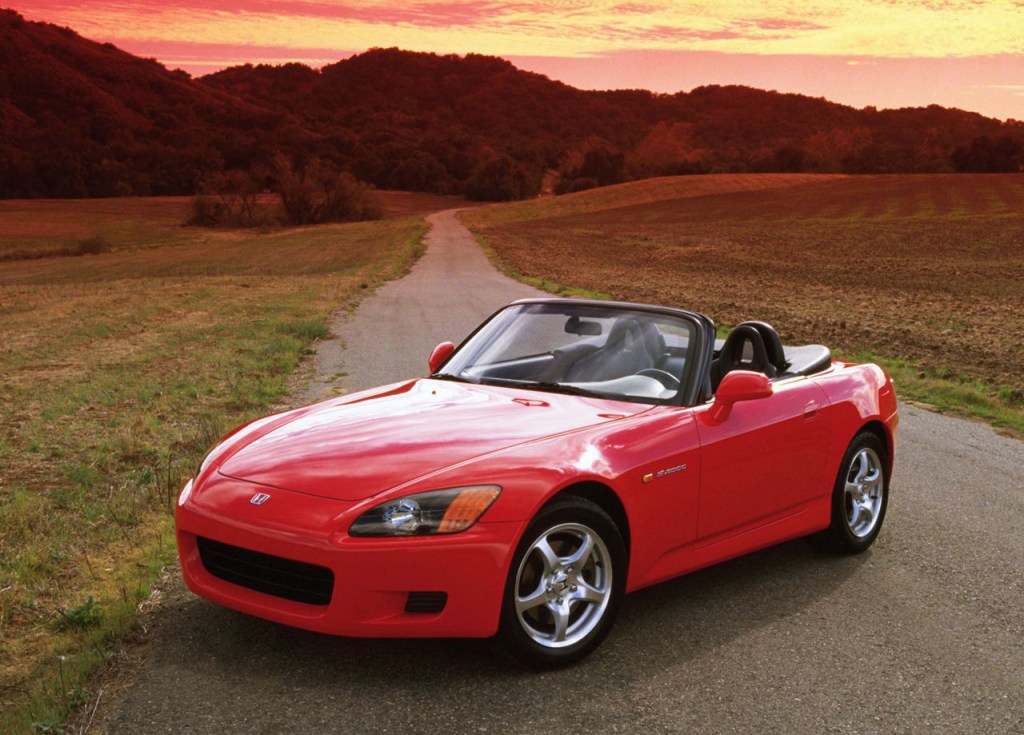 Red 2000 Honda S2000 with the top down on a back-country road
