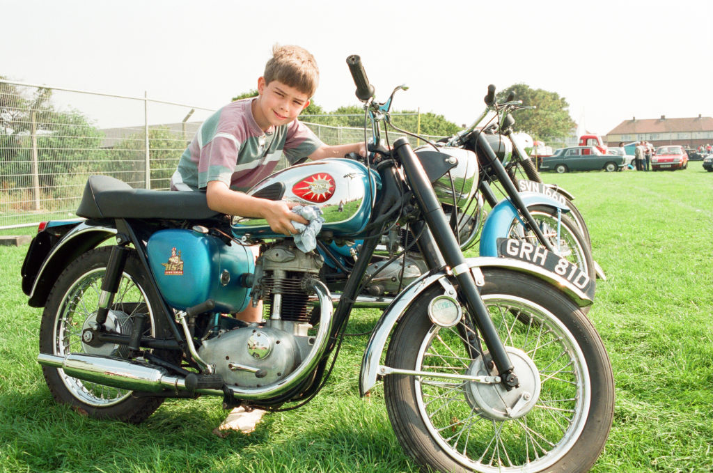 A child polishing a new motorcycle