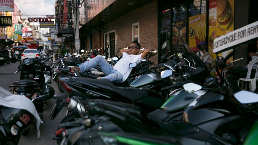 A man reclines at a spot for motorbike rentals