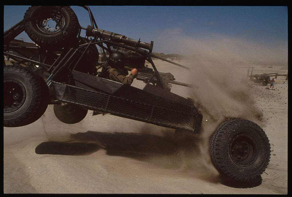 an extreme military grade off-road buggy tumbling through the desert sand