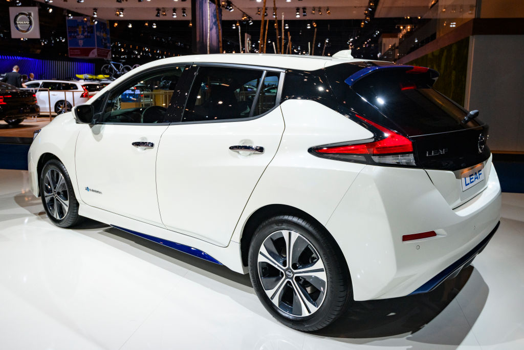 A white Nissan Leaf on display at an auto show