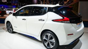 A white Nissan Leaf on display at an auto show