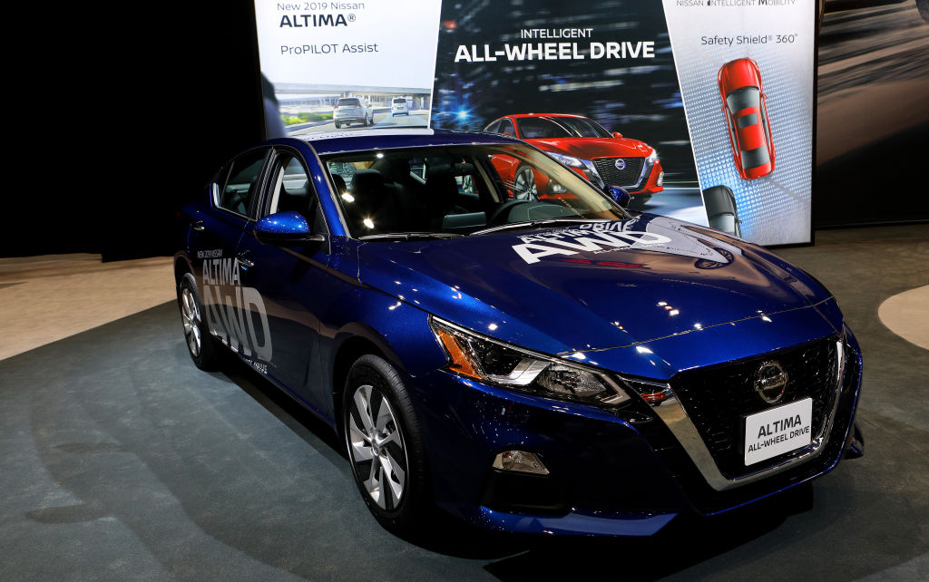A blue Nissan Altima on display at an auto show