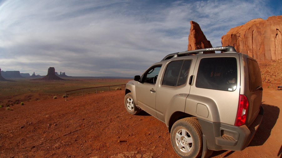 A grey Nissan Xterra off-roading in the desert.
