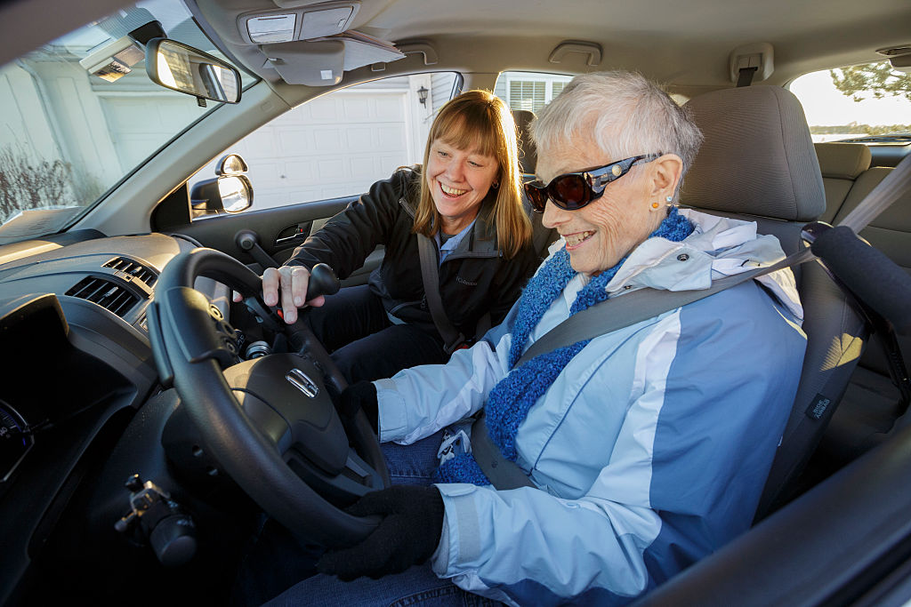 An elderly woman getting ready to drive a car