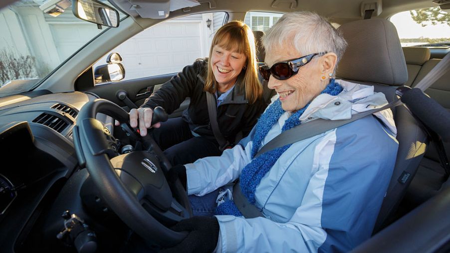 An elderly woman getting ready to drive a car