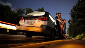 A family stands outside of their Subaru Outback