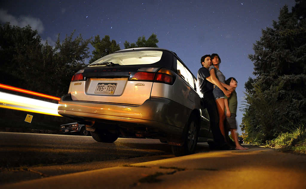 A family stands outside of their Subaru Outback