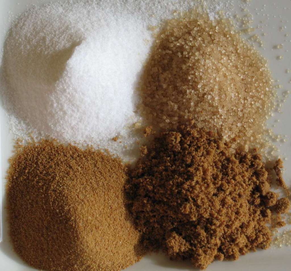 Four different types of sugar arranged in mounds.