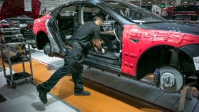 A Tesla worker assembles a car