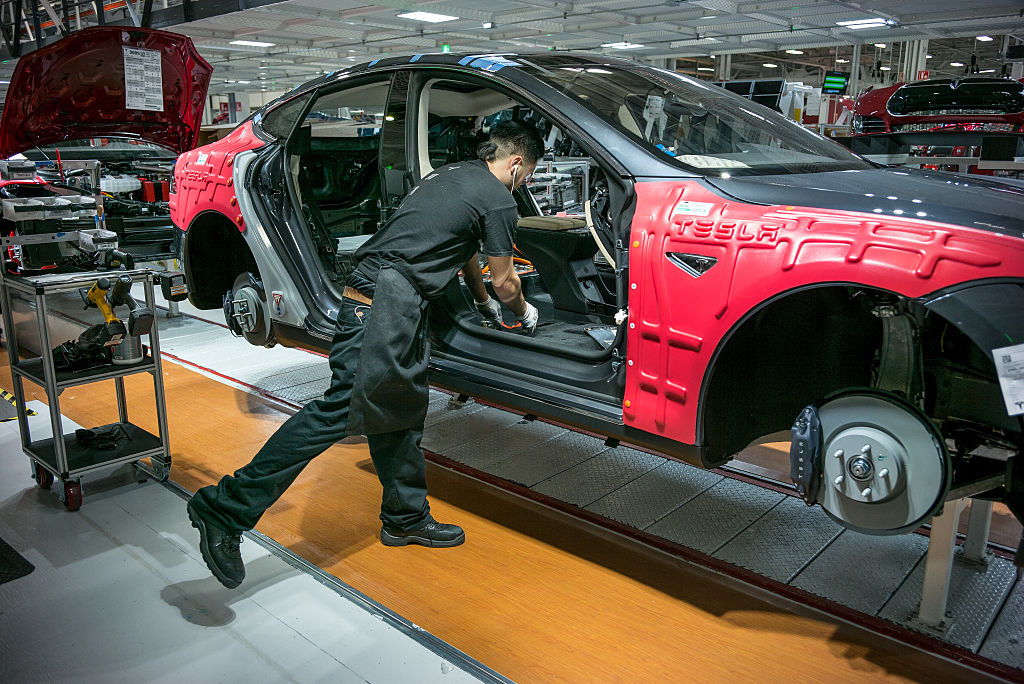 A Tesla worker assembles a car