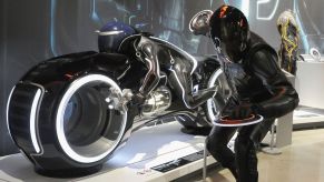 John Stiff as Rizzler/Tron poses along a LightCycle from 'Tron: Legacy' on Cosplay Day at The Petersen Automotive