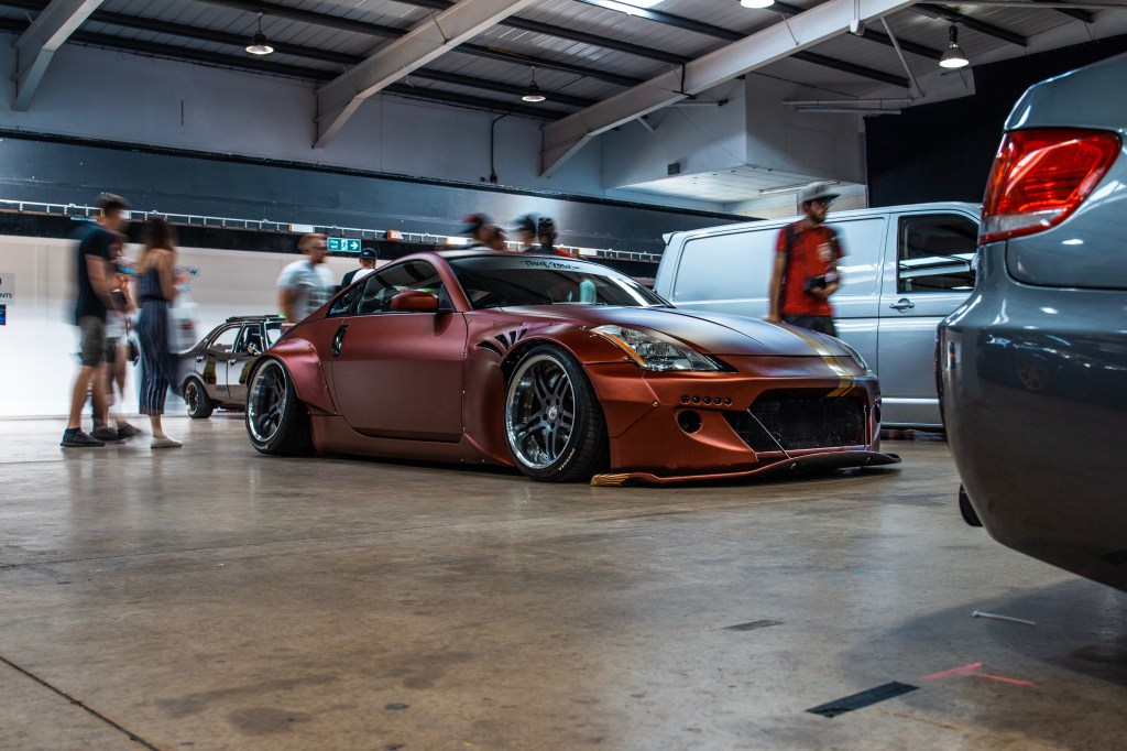A modified Nissan 350Z with a flamboyant body kit parked in a garage.